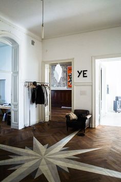 a room with wooden floors, white walls and a large star pattern on the floor