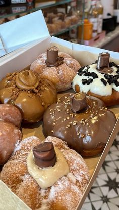 a box filled with donuts covered in frosting and toppings on top of each other