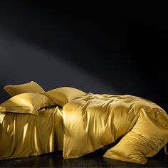 a gold colored comforter and pillows on a black background with the words sondson above it