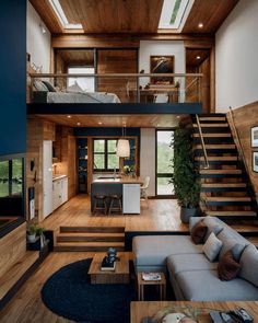 a living room filled with furniture next to a stair case and wooden floored walls