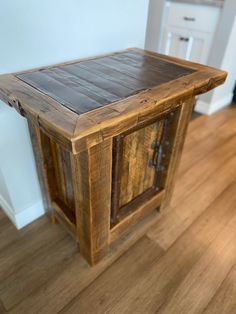 a wooden table with two doors on the top and bottom, sitting in a room