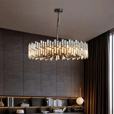 a chandelier hanging from the ceiling in a living room with dark walls and curtains