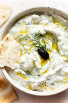 a white bowl filled with dip and pita chips