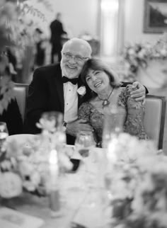 an older man and woman sitting at a table