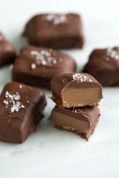 several pieces of chocolate with white sprinkles on them sitting on a table