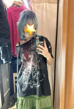 a woman with blue hair taking a selfie in front of a mirror while wearing a black shirt and green skirt