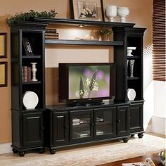 a black entertainment center with a flat screen tv on it's stand and shelves