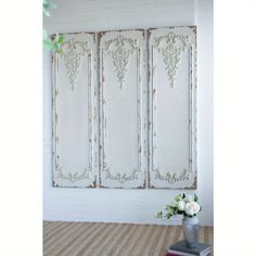 a vase with flowers sitting on top of a table next to an old window frame