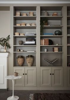 a living room with bookshelves and vases on the shelves next to each other