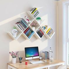 a desk with a computer and bookshelf above it