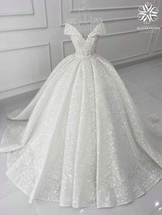 a white ball gown with an off the shoulder neckline and lace detailing on it