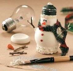 a snowman figurine sitting on top of a table next to some tools