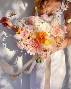 a woman holding a bouquet of flowers in her hands