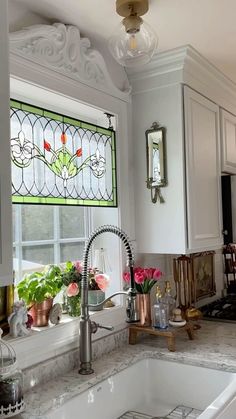 a kitchen sink under a stained glass window