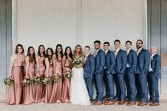 a group of people standing next to each other in front of a white wall wearing suits and ties