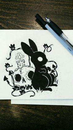 a black and white drawing of a rabbit sitting in front of a skull on a piece of paper