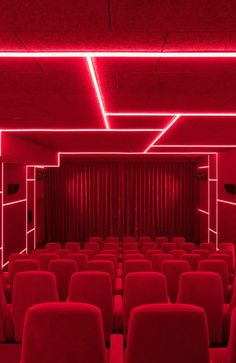 an empty theater with red curtains and seats