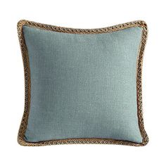 a light blue pillow with gold trimmings on the edges and an embroidered border