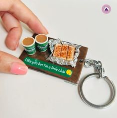 a person is holding a keychain with some food on it