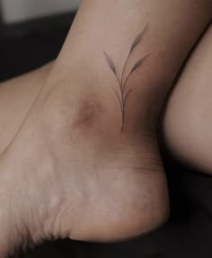 a woman's foot with a small flower tattoo on the side of her leg