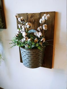 a potted plant is hanging on the wall with cotton floss in it's basket