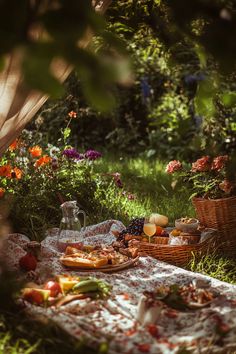 an outdoor picnic with food and drinks on the ground in front of flowers, grass and trees