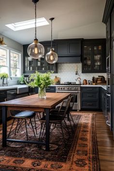 a kitchen with black cabinets and an area rug on the floor that has a wooden table in it