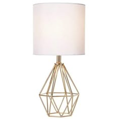 a table lamp with a white shade on the base and a gold metal cage design