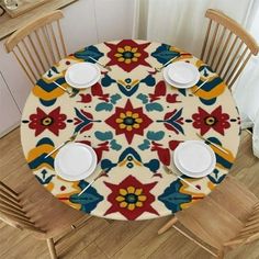 the table is set with four plates and two cups on it, along with three chairs