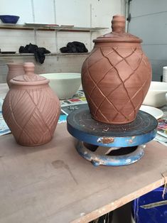 three clay vases sitting on top of a table