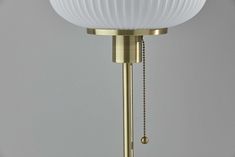 a lamp with a white glass shade on it's head and chain hanging from the base