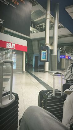 people sitting in chairs at an airport waiting for their luggage