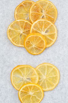 several slices of lemon are arranged on a white surface