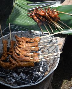 several skewered meats are being cooked on a grill