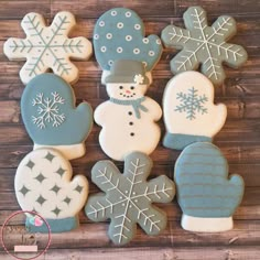 decorated cookies with snowmen and mittens are on a wooden table, ready to be eaten