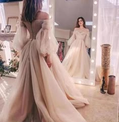 a woman in a wedding dress looking at herself in the mirror