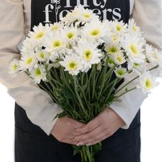 a woman holding a bunch of white flowers in her hands with the words fifty fingers written on it