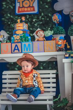 a little boy sitting on top of a bench wearing a cowboy hat and shirt with toy animals in the background