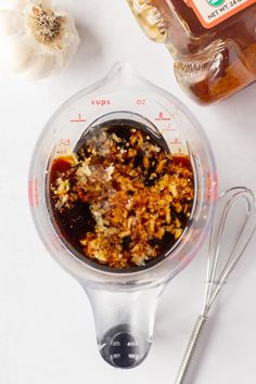 a blender filled with food sitting on top of a counter next to garlic and seasoning