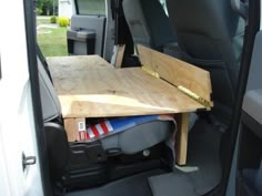 the back end of a van with a wooden table in it