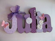 a purple and white wooden sign with flowers on it