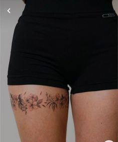 a woman's thigh with flowers on it and the bottom half of her leg