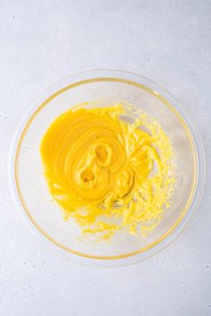 a bowl filled with yellow liquid on top of a white table