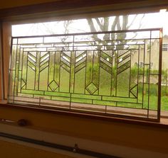 a window that has a glass design on the side of it and grass in the background