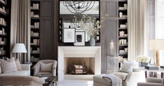 a living room filled with lots of furniture and a fire place surrounded by bookshelves