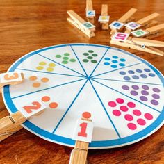 a wooden peg board with numbers on it and clothes pins in the shape of a circle