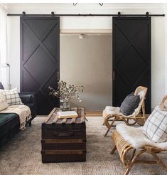 a living room filled with furniture and a sliding door in the wall next to it