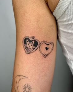 a woman's arm with two tattoos on it, one has a cat and the other has a heart