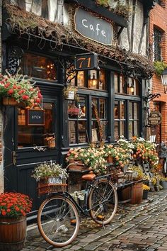 bicycles are parked in front of a cafe with flower pots on the side of it