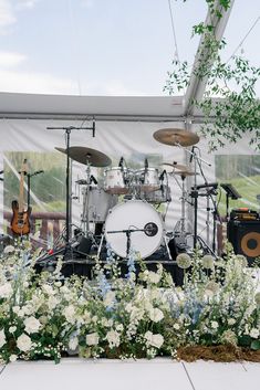 a group of musical instruments sitting on top of a white flower covered field under a tent